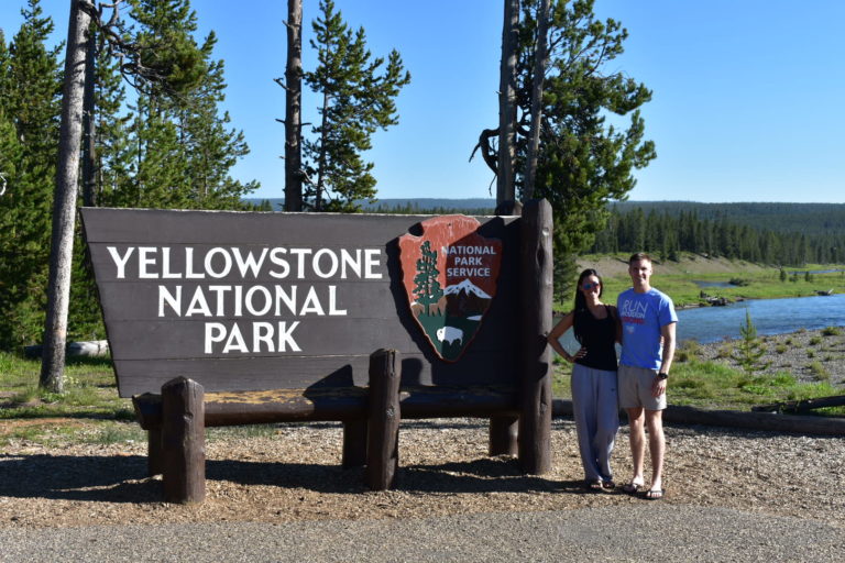 Man and women in front of Yellowstone sign