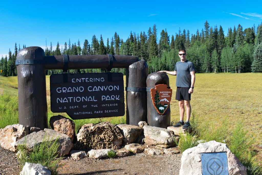 Man in gray shirt standing at the Grand Canyon national park north rim entrance