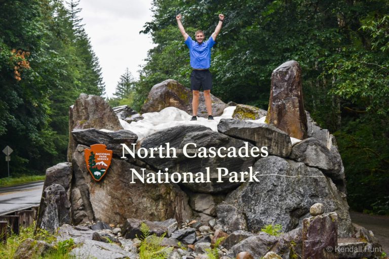guy in blue shirt standing on top of north cascades park entrance