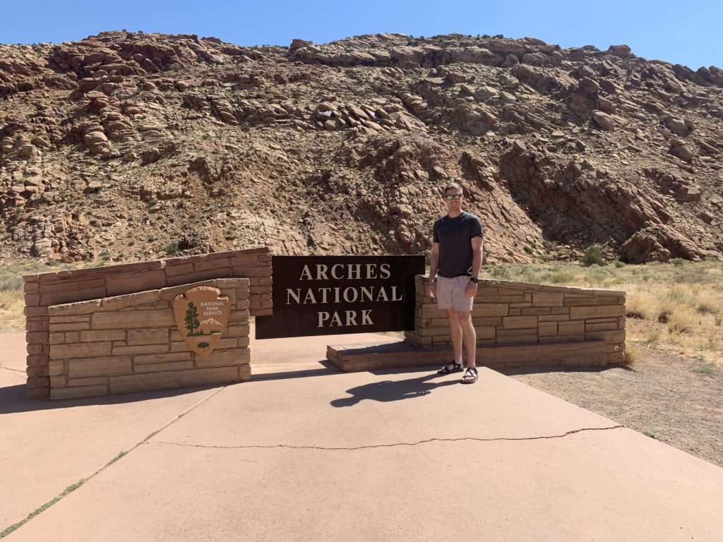 standing in from of arches national park entrance