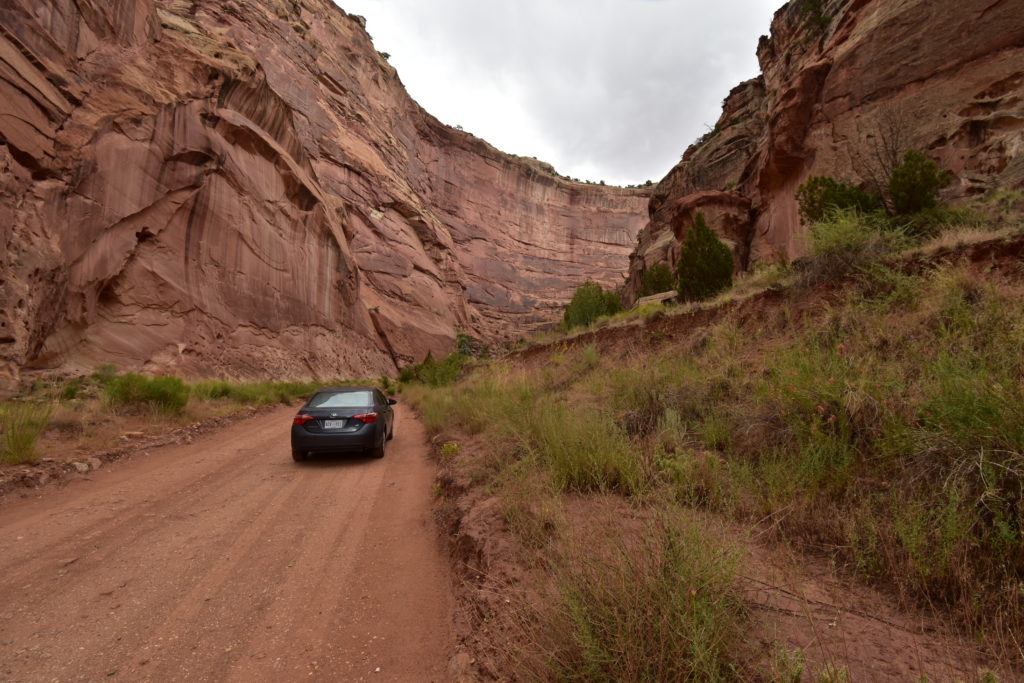 Steep Red canyon walls with gray car