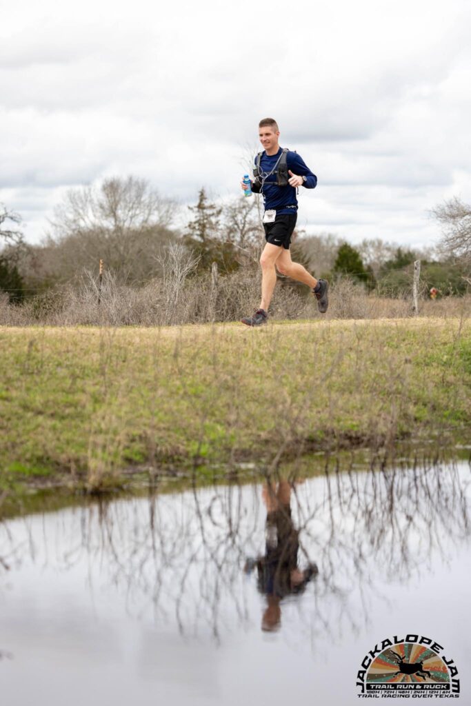 man running with lake in the foreground